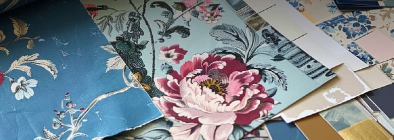 Close-up of wallpaper recreation in progress with samples, color chips and test prints