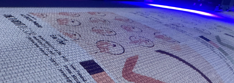 A closeup photo of a design being printed on grasscloth wallpaper