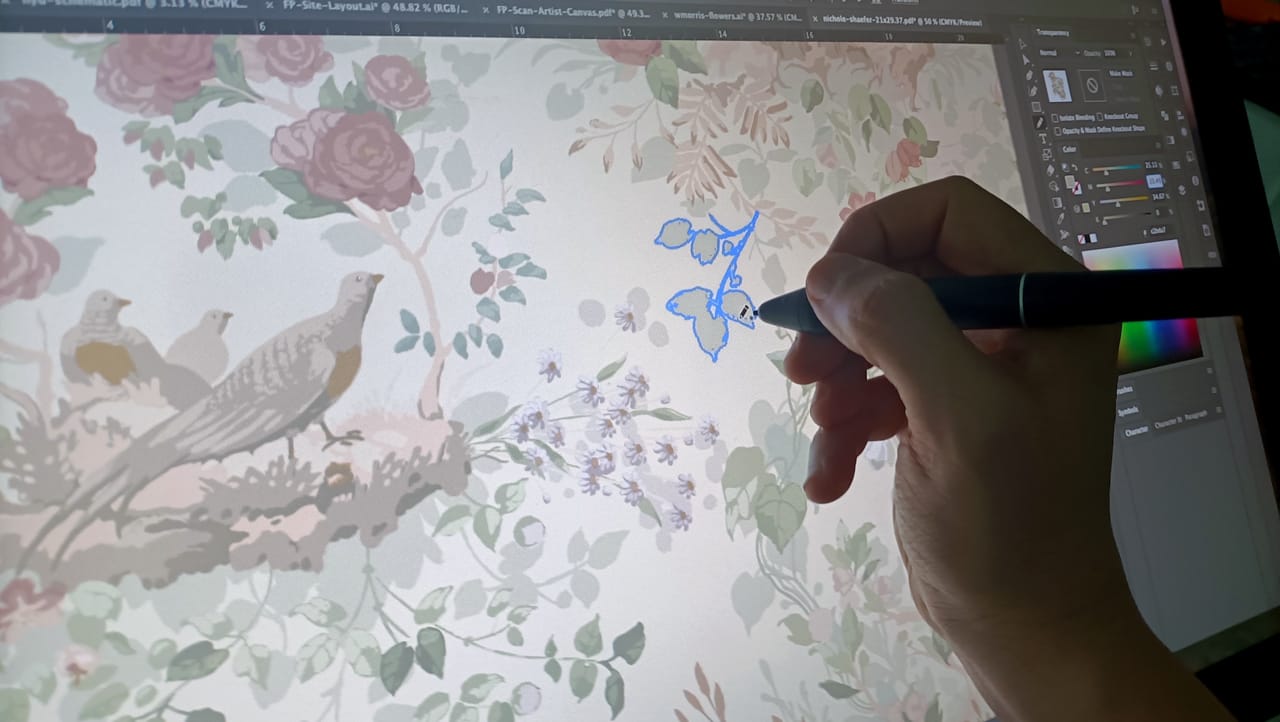 An artist hand-rendering fine detail in a wallpaper pattern
