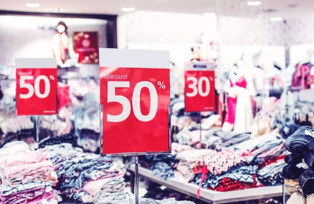 Interior shot of a retail shop with lots of sales signs posted throughout