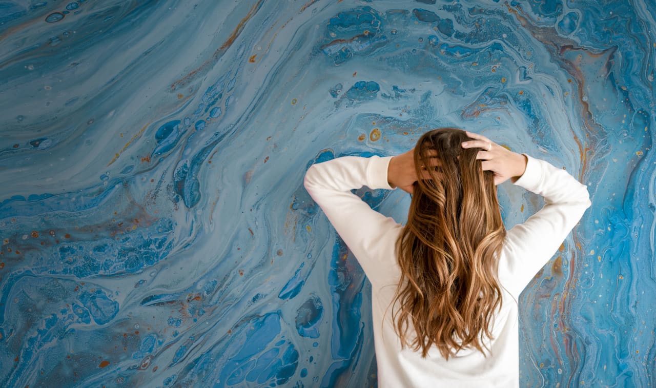 Photo of a woman in front of a printed marble wall