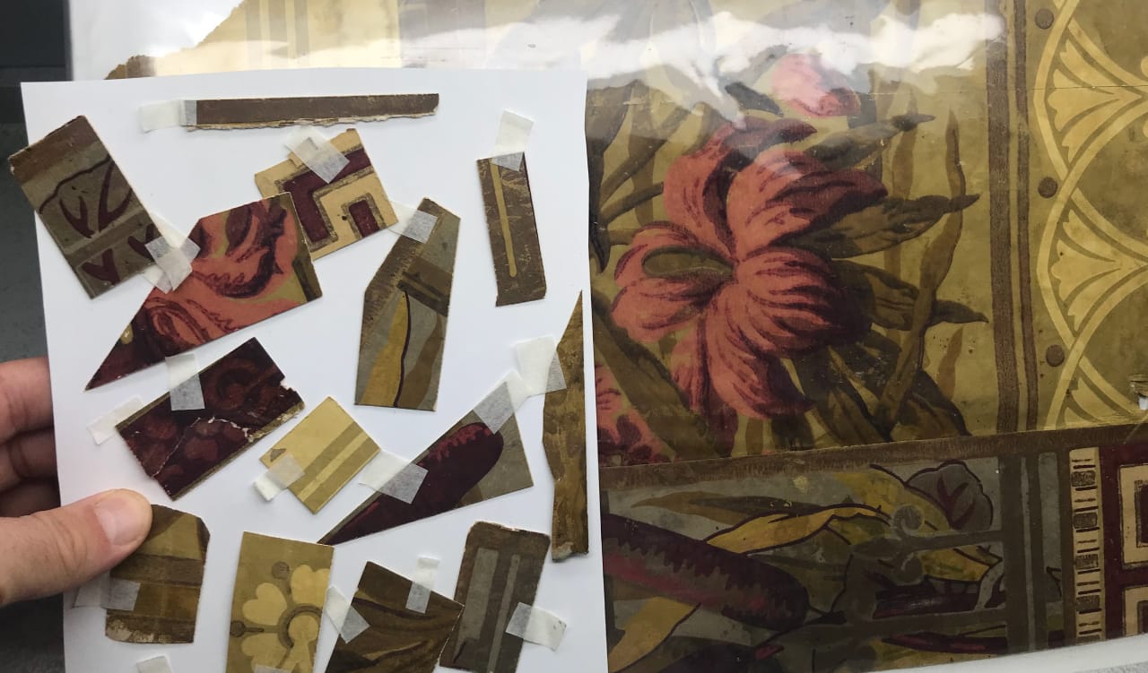 Damaged original 1882 wallpaper fragments from the Glenmore Mansion foyer laid out for digital reconstruction and historic color matching